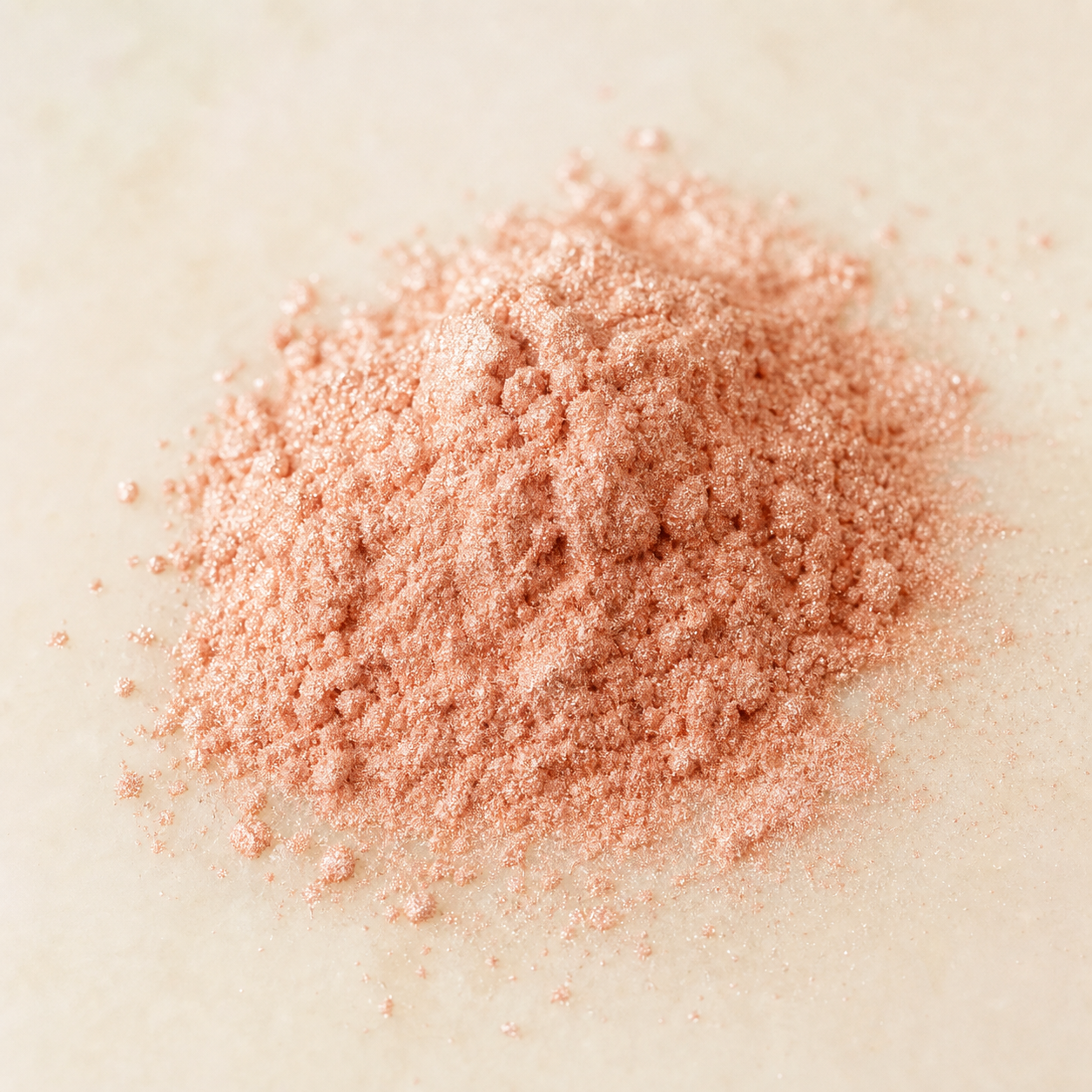Natural mineral color powder photographed in soft pink tones.